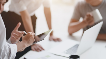 colleagues work around a laptop