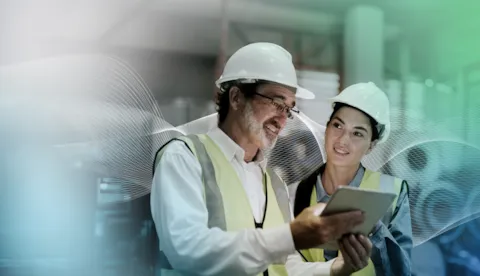 two workers in high vis and hard hats use synergi life software