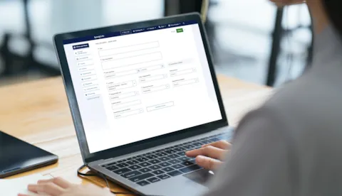 office worker uses Synergi Life software on laptop