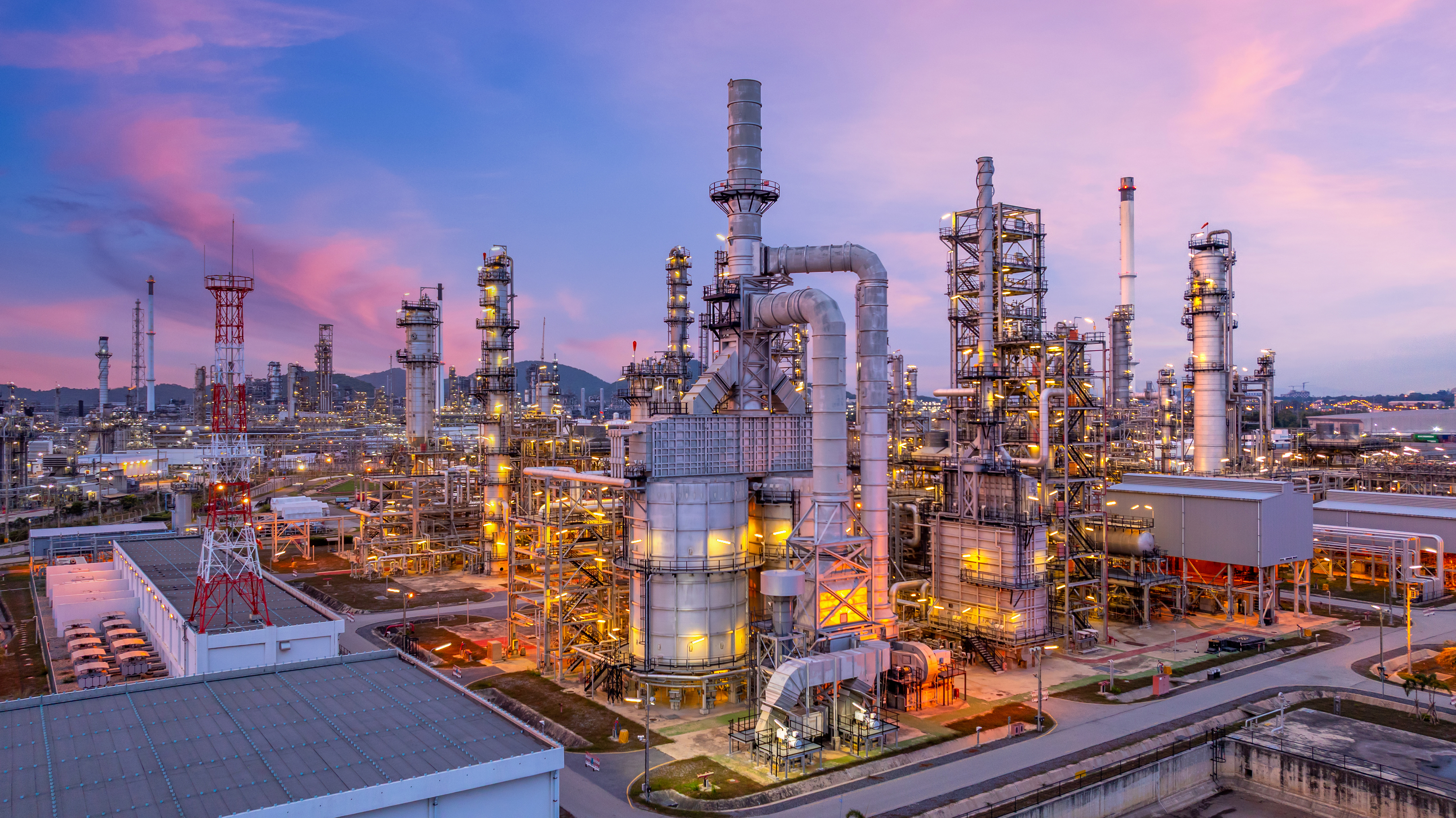 Industrial complex at sunset, illustrating decarbonisation pathways, emissions reductions, and third-party validation for carbon credit projects