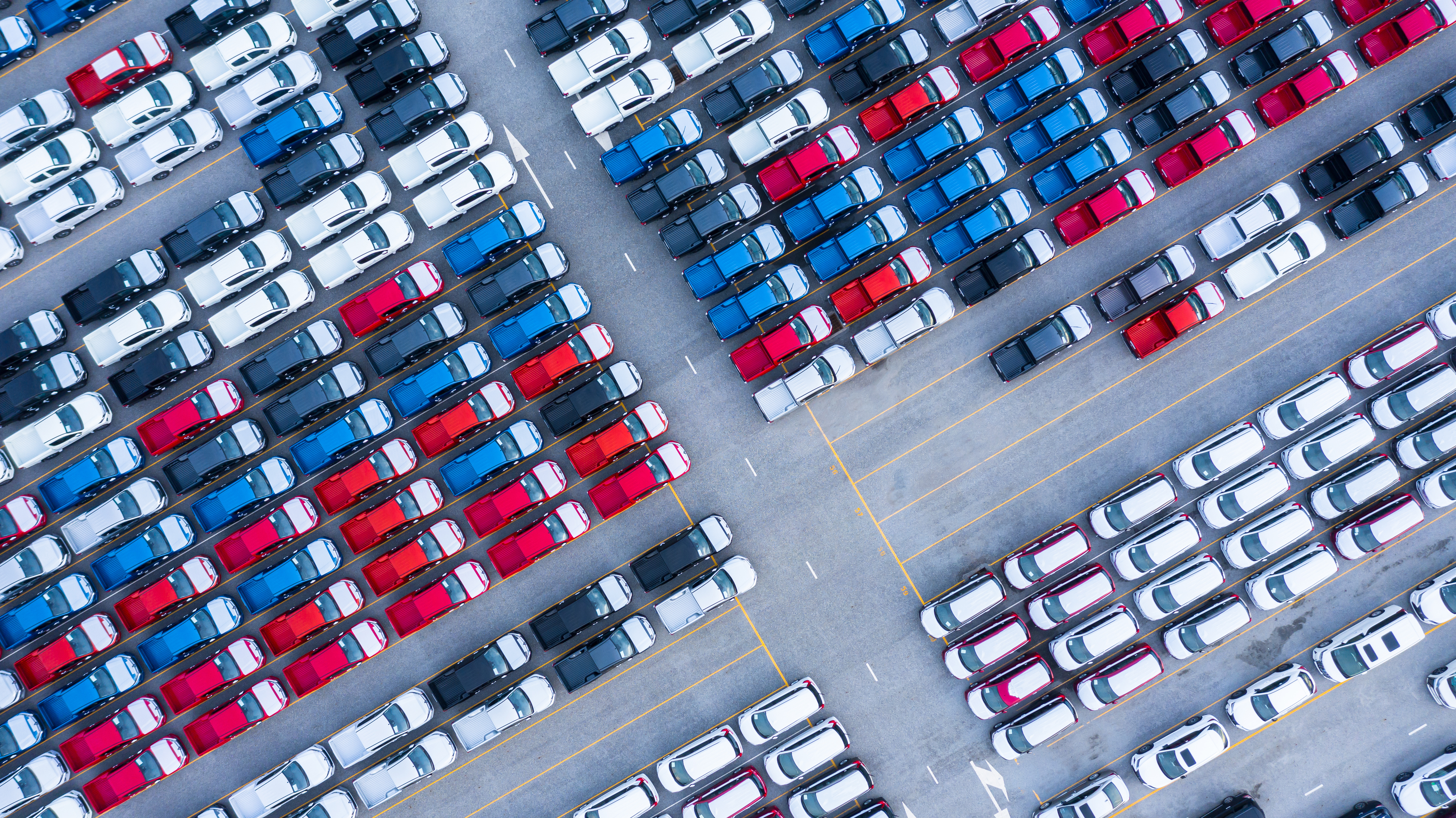 Aerial view of hundreds of parked vehicles, representing scalable automotive operations and lifecycle process optimisation