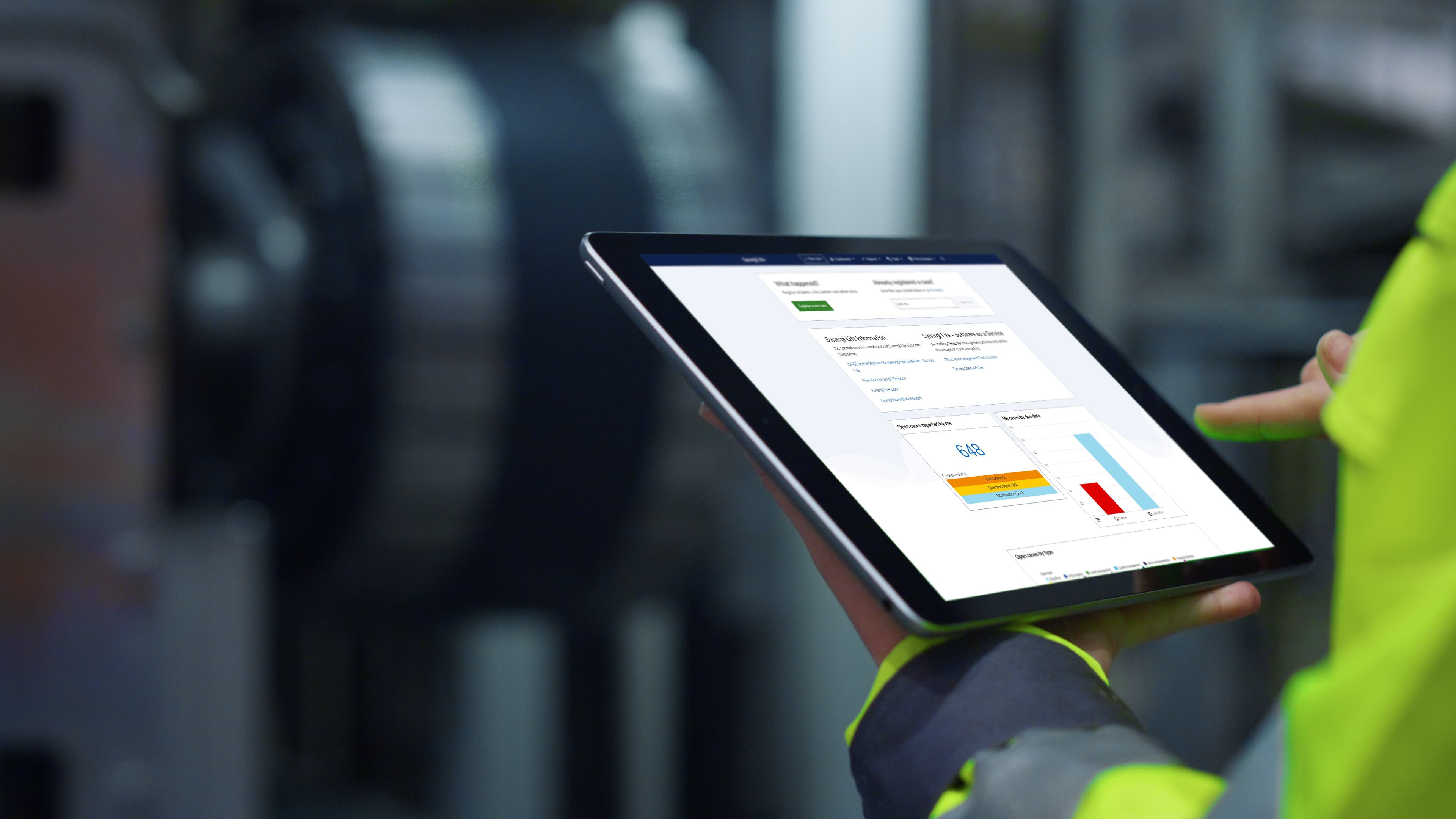 worker looks at Synergi Life software on tablet