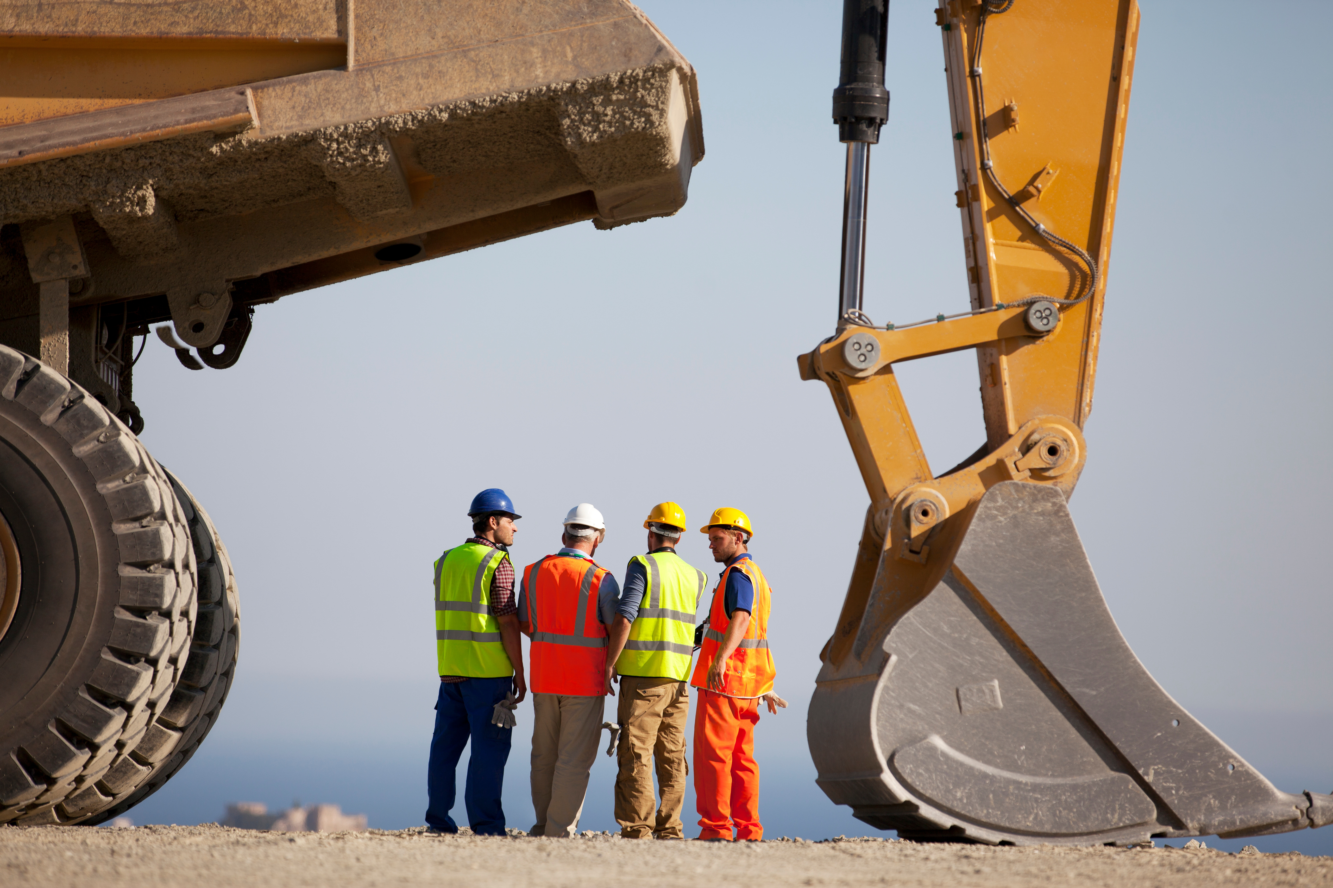 Engineers inspecting heavy construction machinery on-site, illustrating CE marking readiness and machinery safety compliance