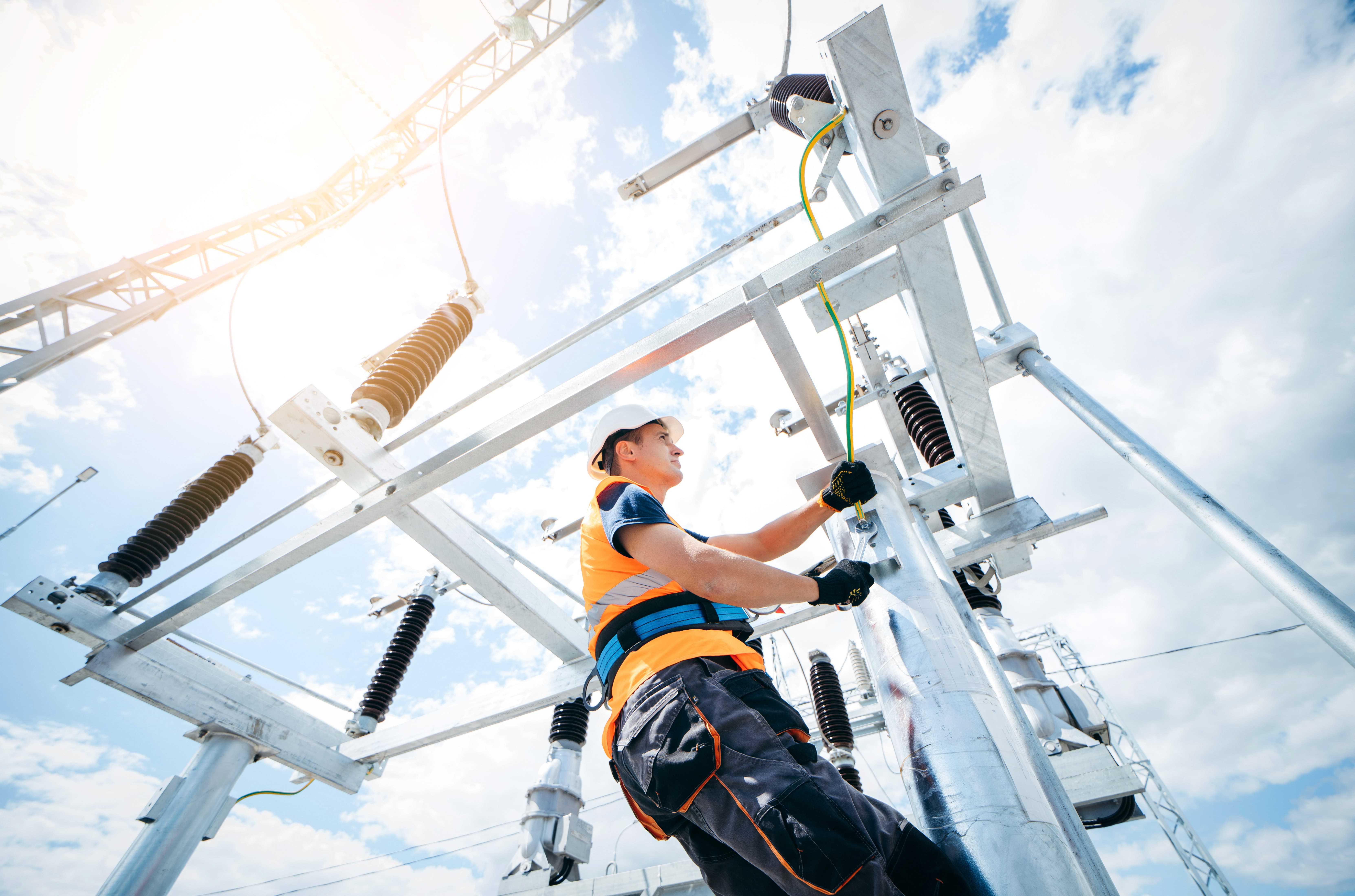 electric grid worker scales pylon