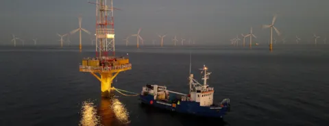 Oil rig and wind turbines in the sea