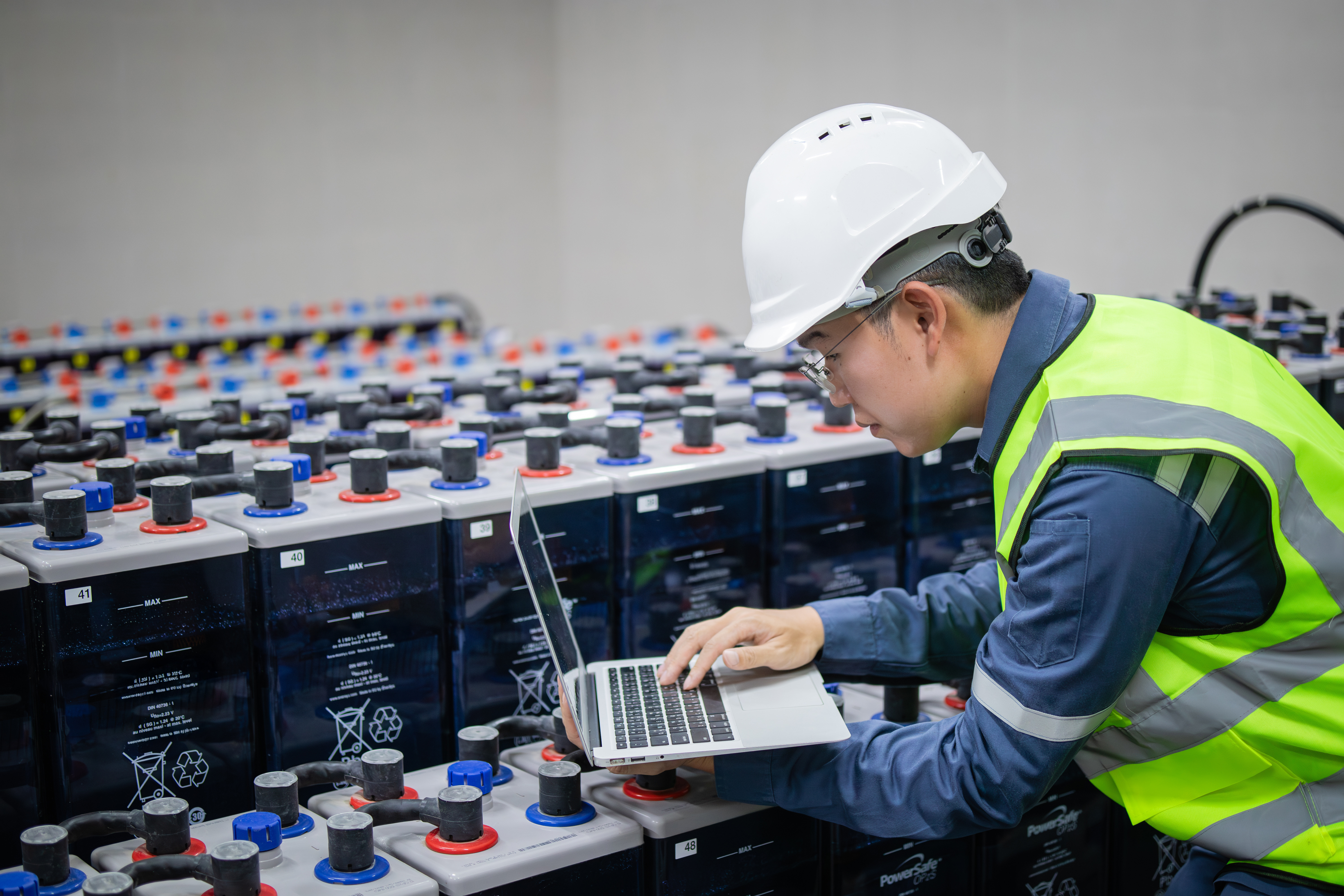 Engineer inspecting battery modules on a factory line, representing independent performance and safety validation