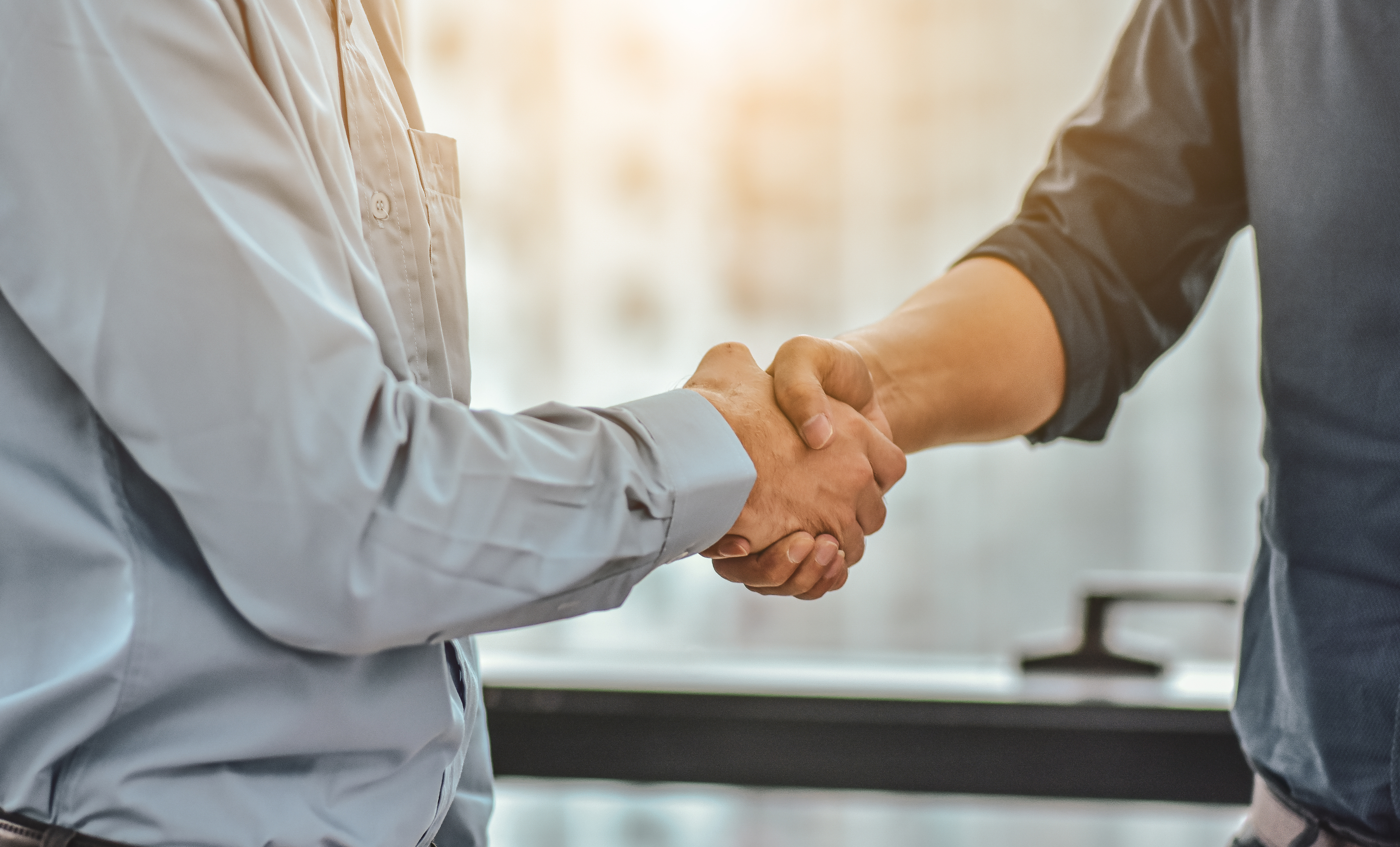 Business professionals shaking hands over sustainability documents, symbolizing trusted collaboration in sustainable finance and taxonomy development
