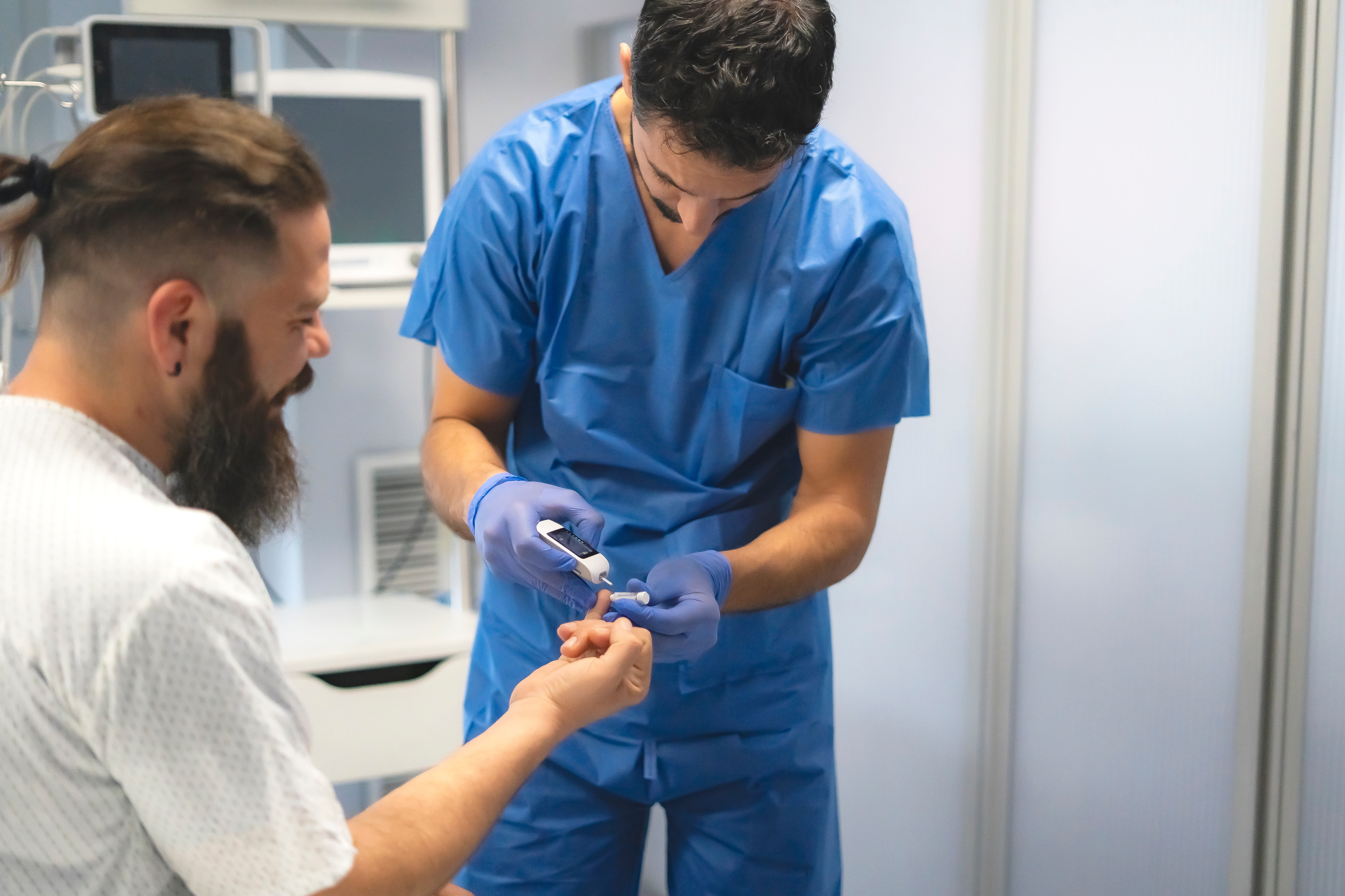 Clinician assisting a patient with a blood glucose test, demonstrating evidence-based glycaemic management aligned with DNV’s Advanced Glycaemic Management Certification