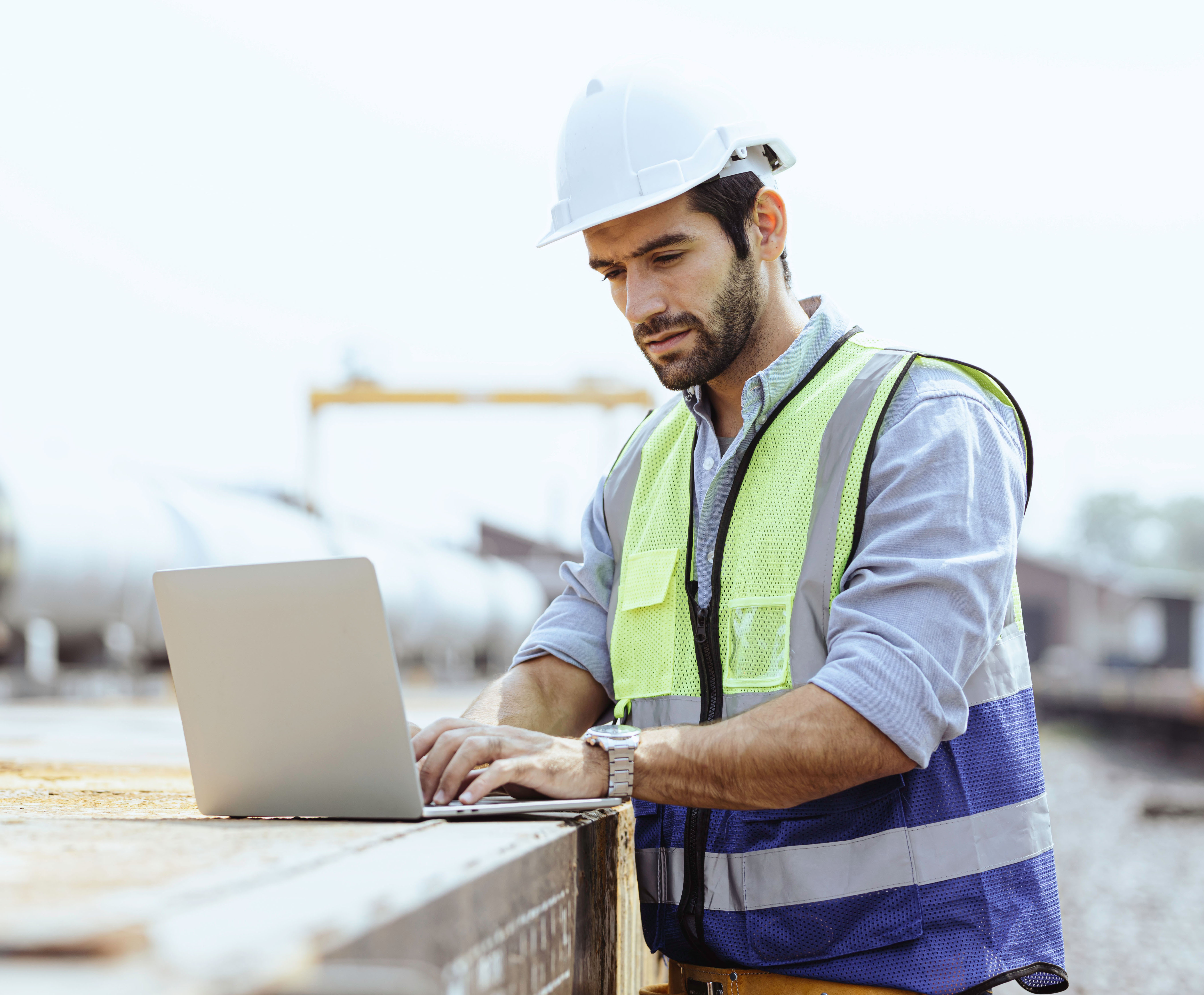 Heavy-duty industrial engineers stand in a pipeline manufacturing facility using digital tablet