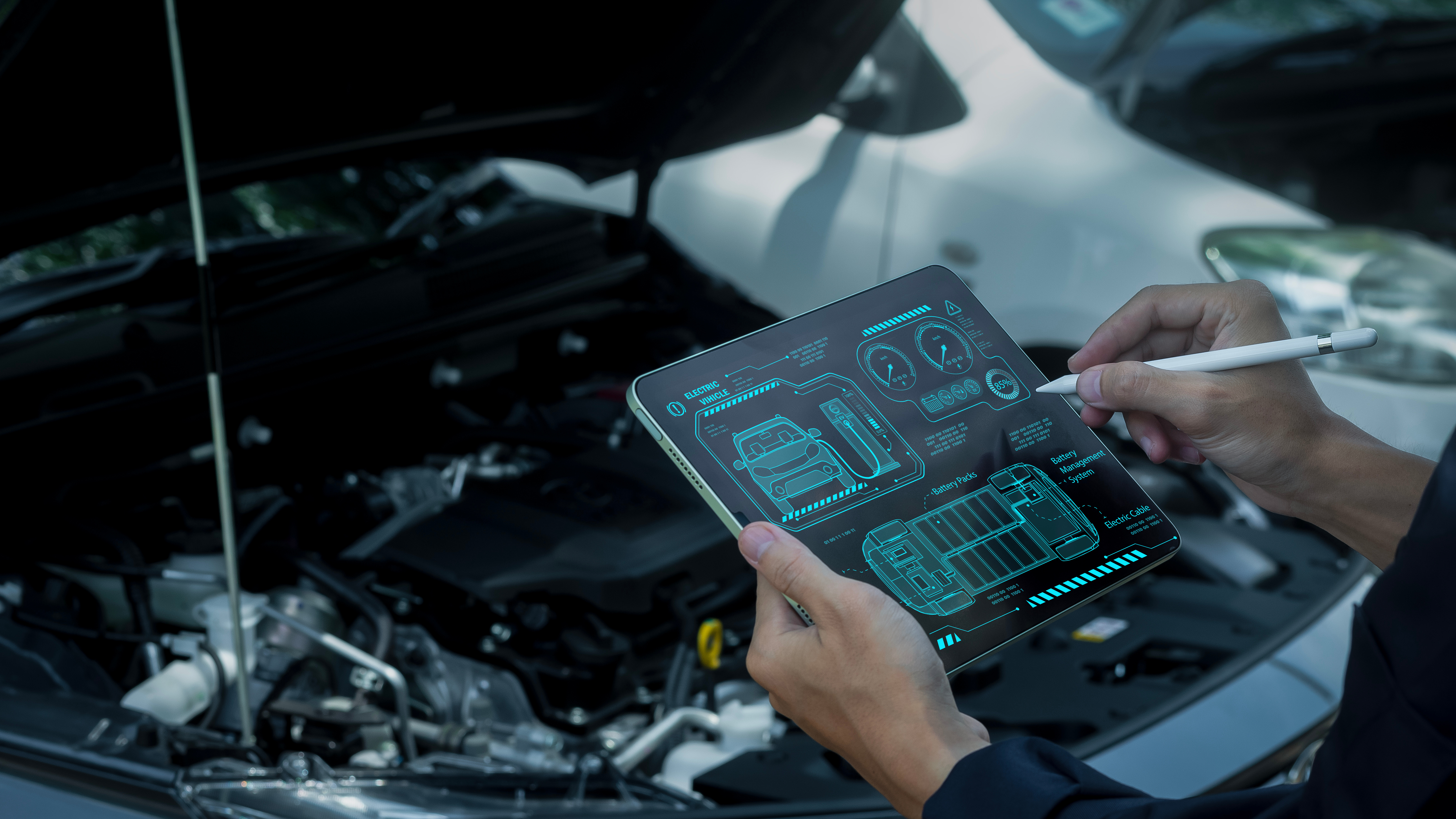 Engineer using a diagnostic laptop inside a vehicle to assess software and electronic systems for cybersecurity vulnerabilities