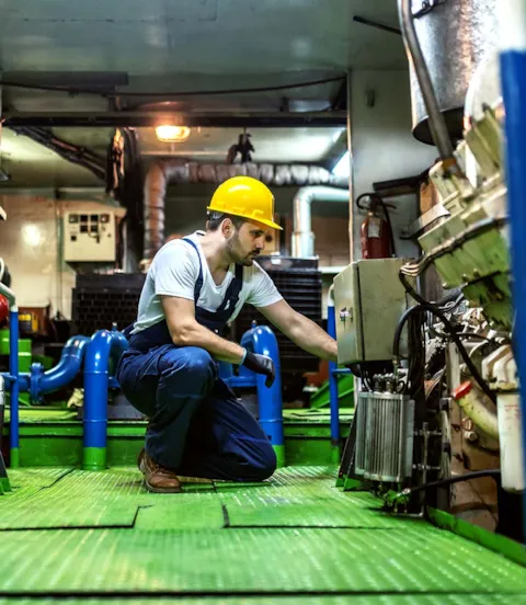 Crewmember inspecting machinery