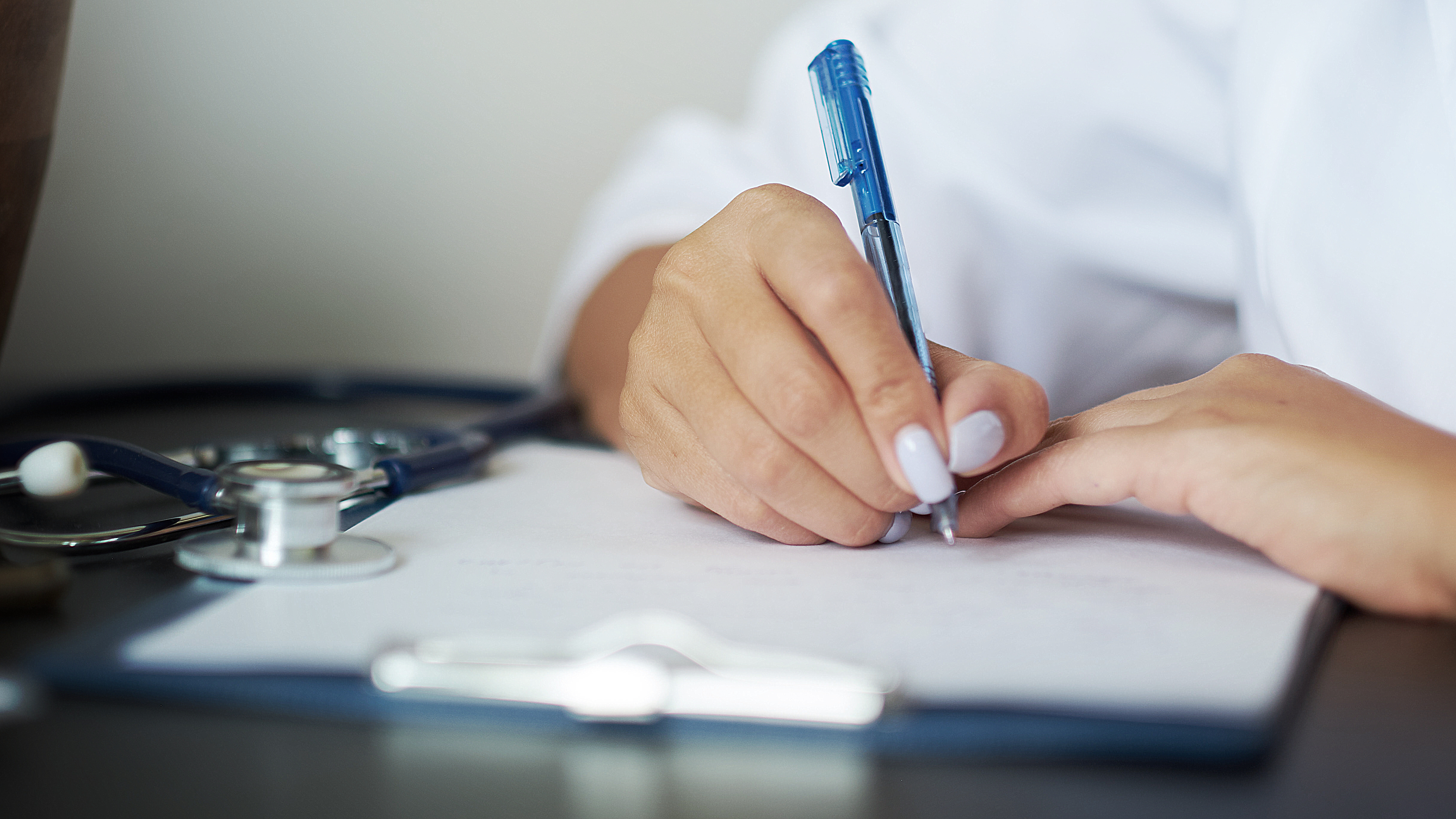 Healthcare professional using a digital tablet with medical icons and data overlay, representing innovation, quality management, and compliance in medical technology.