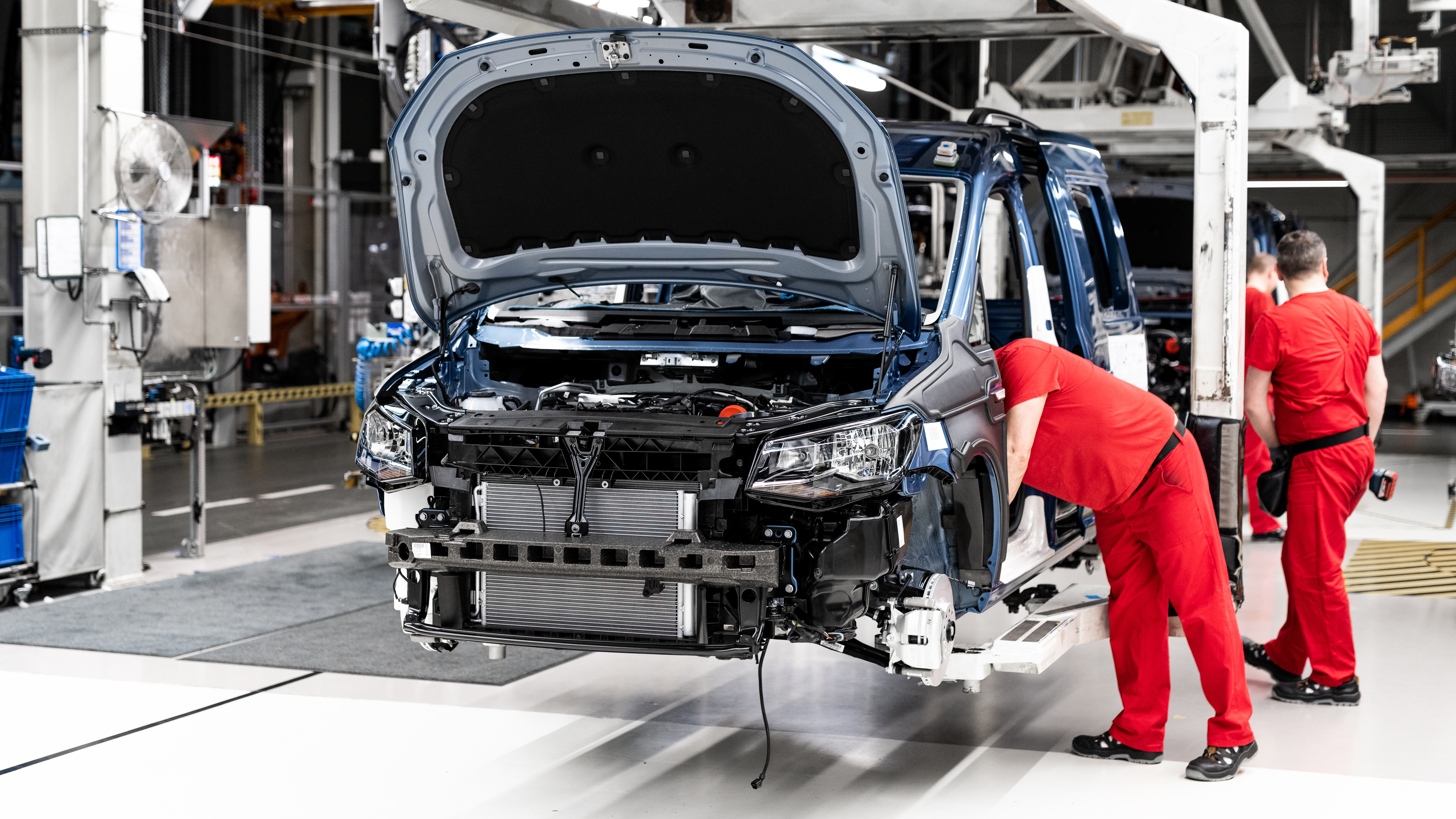 Engineers inspecting a vehicle engine on the production line, illustrating assessment of functional safety gaps against ISO 26262 requirements
