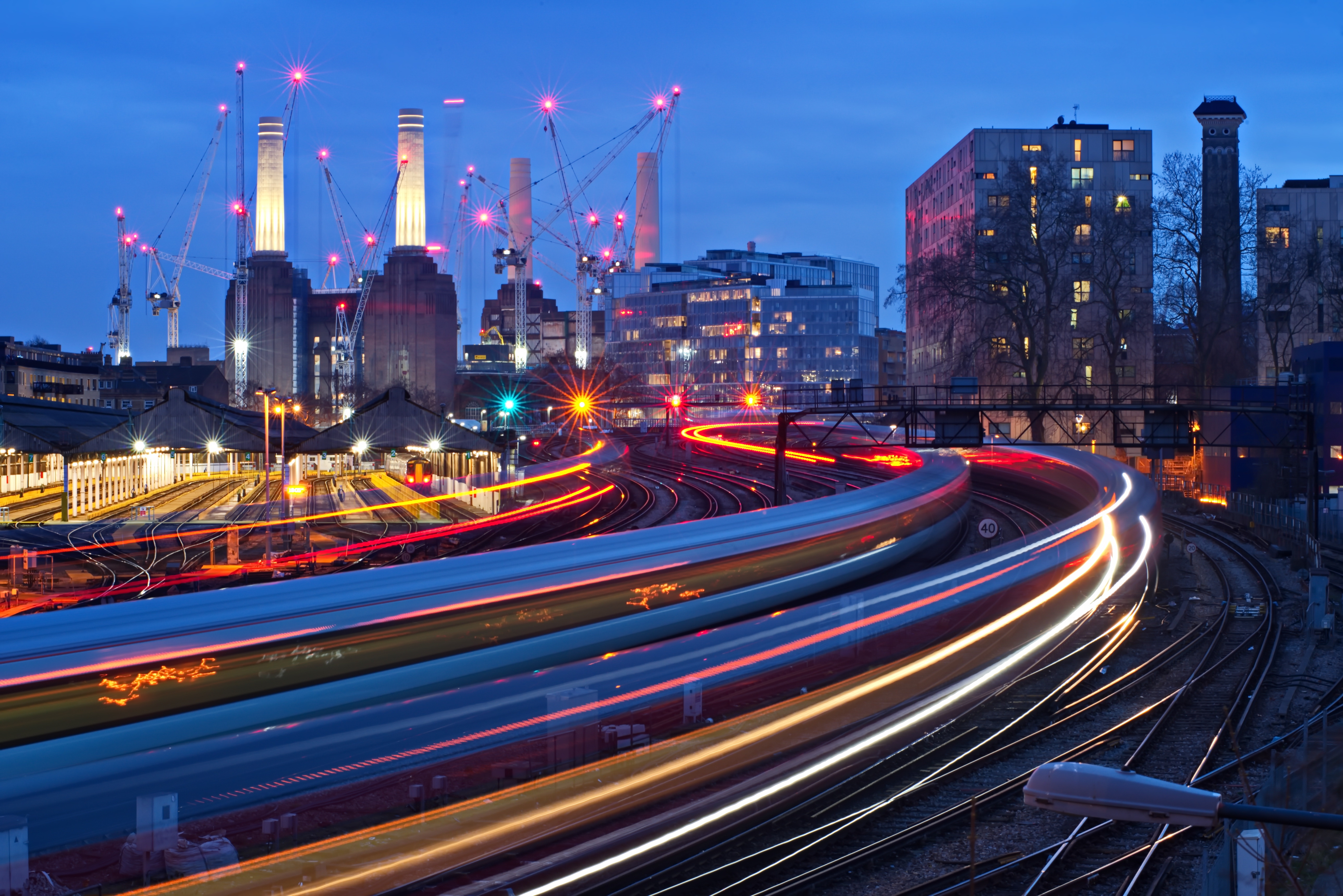 Railway network operating through a city at dusk, highlighting optimized performance, reliability and long-term rail system planning