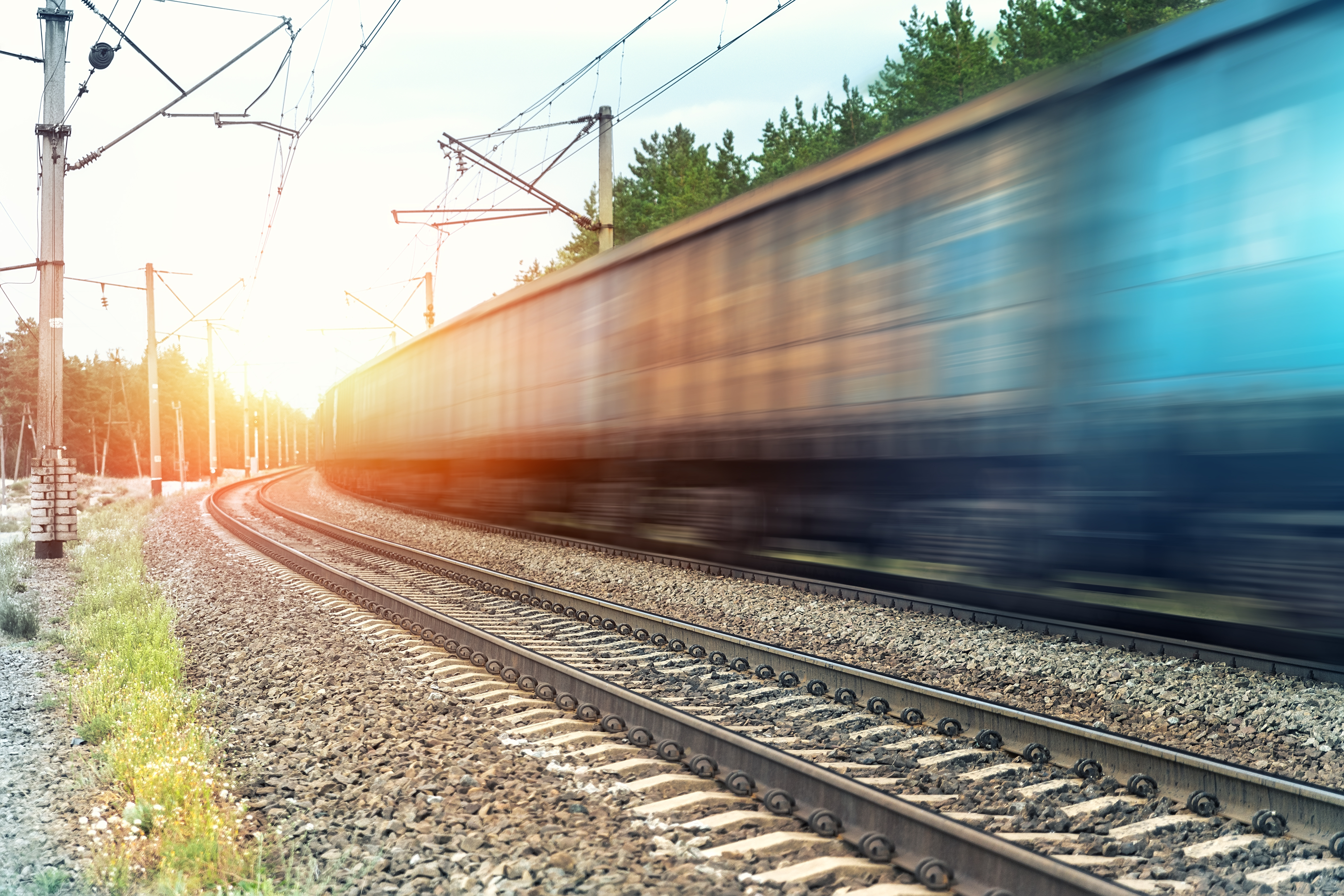 High-speed train in motion on electrified railway line, symbolizing digital innovation and modern rail infrastructure.
