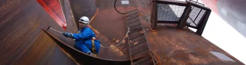 Work environment - surveyor climbing on a corroded installation