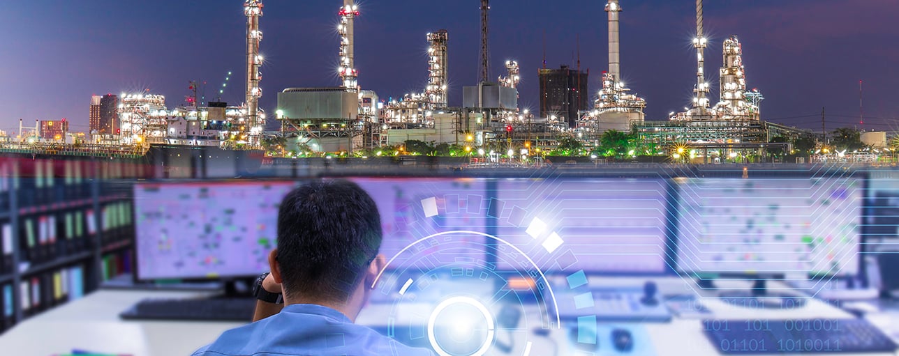 Man in front of several PC screens