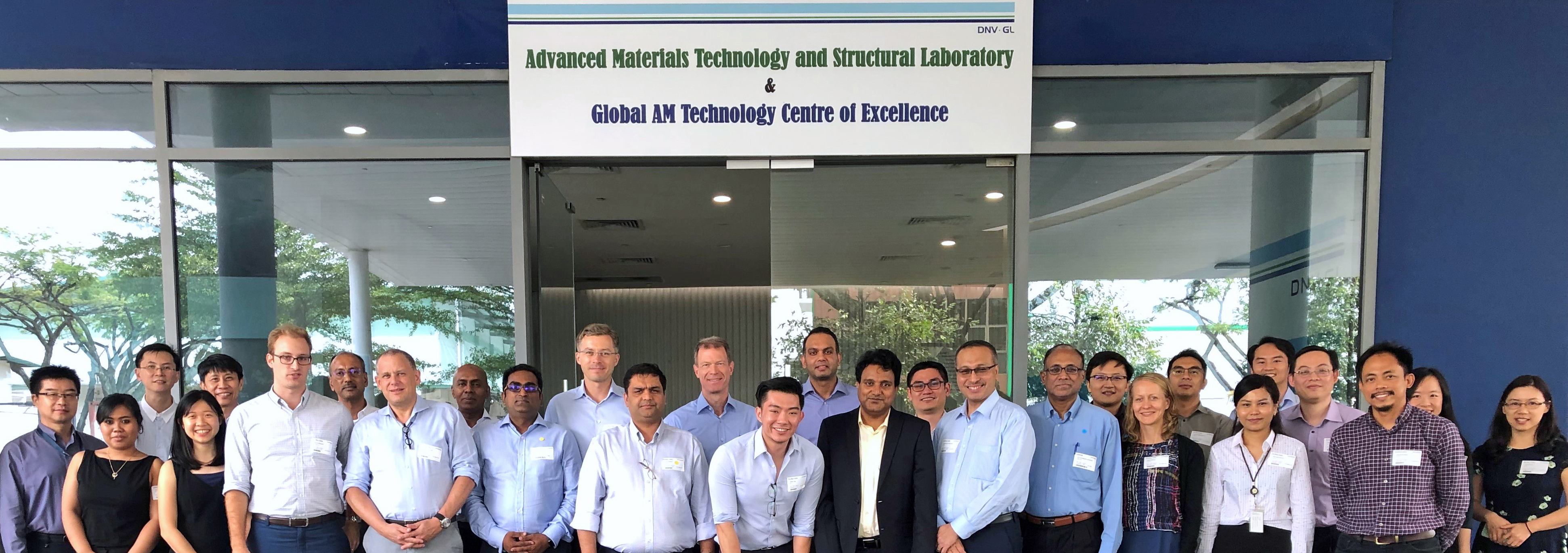 Joint industry program participants in front of the main entrance to the Global Additive Manufacturing Technology Centre of Excellence in Singapore