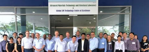 Joint industry program participants in front of the main entrance to the Global Additive Manufacturing Technology Centre of Excellence in Singapore