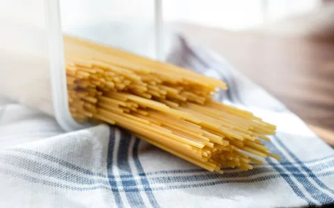 Pile of raw thin spaghetti in plastic container