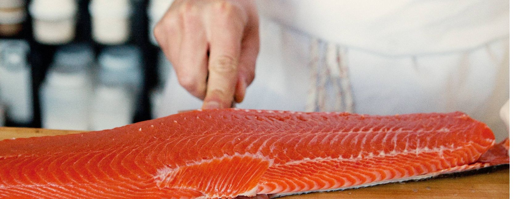Chef removing the skin of a salmon filet