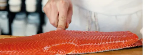 Chef removing the skin of a salmon filet