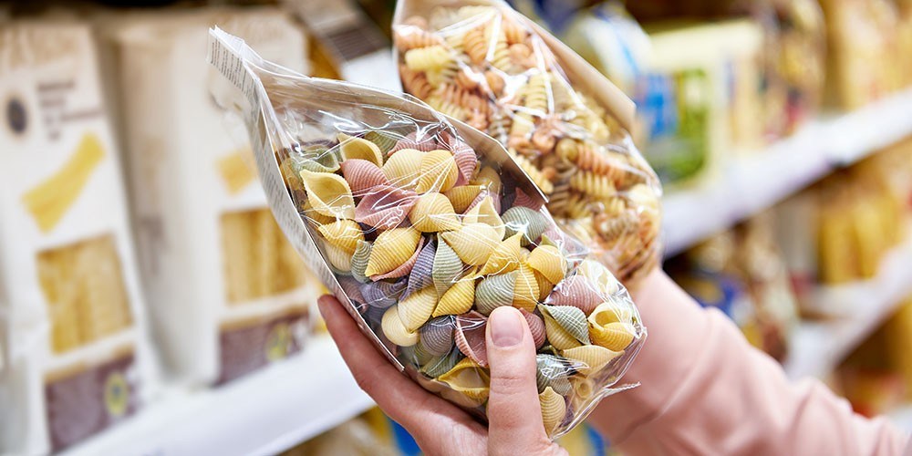 Woman buyer with a package pasta in the shop