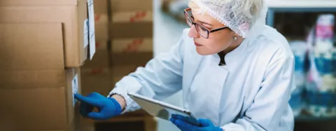 Female worker checking stack of boxes