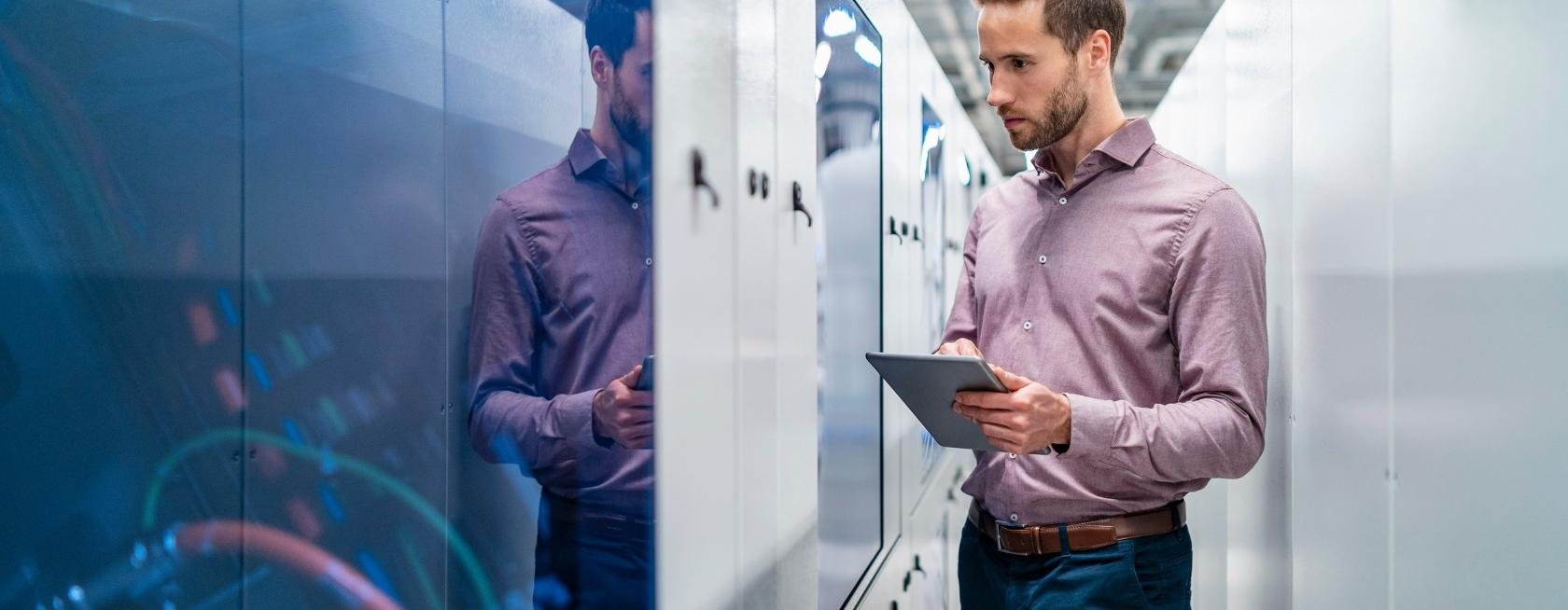Businessman using tablet at a machine in a factory