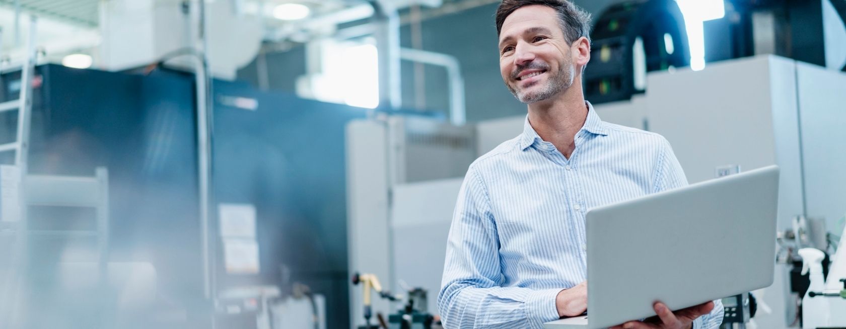Businessman holding laptop while working in industry