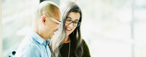 Coworkers looking at data on digital tablet in office