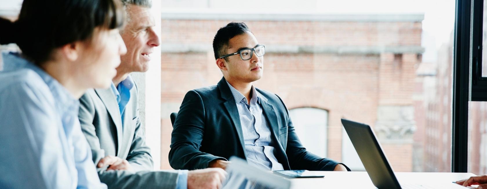 Listening to presentation during project meeting in office