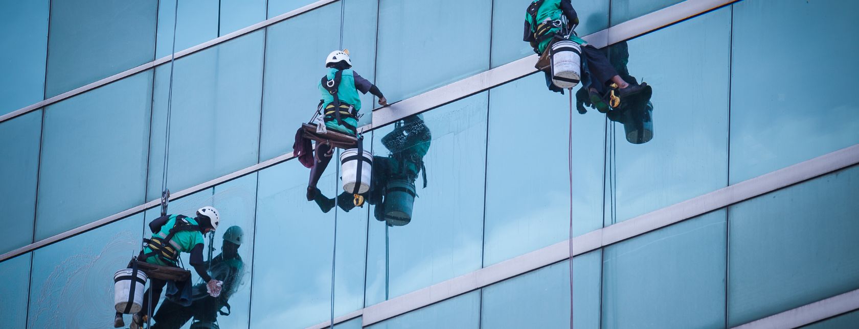 Group of workers cleaning windows service on high rise building