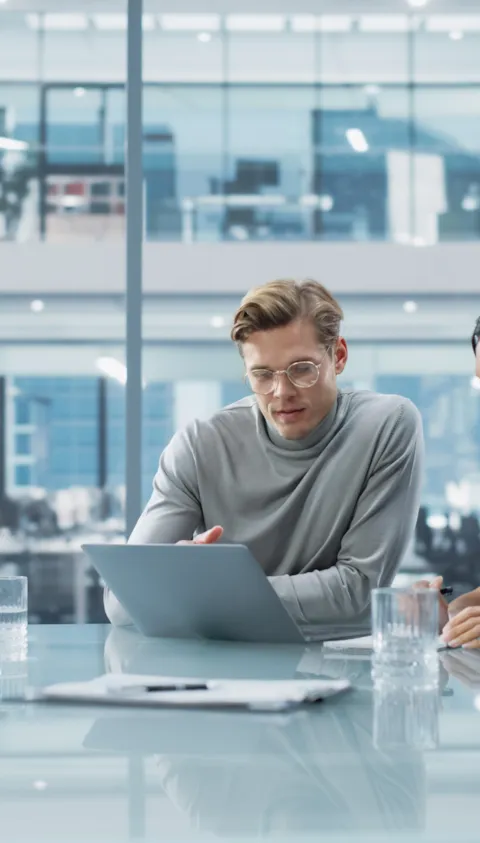 Team of Two People Talk in a modern meeting room, discussing Growth Strategy.