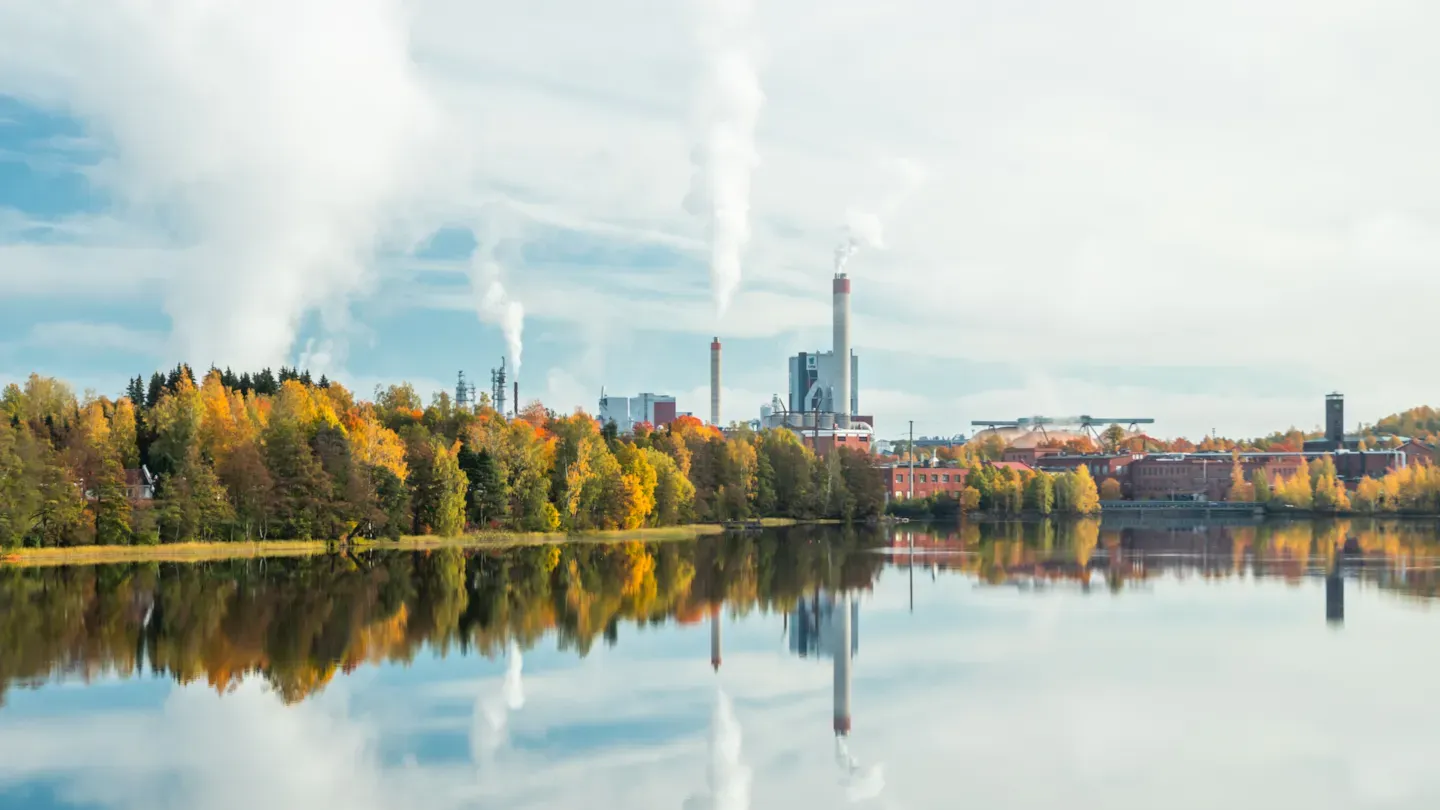 Industrial facility reflected in a lakeside landscape
