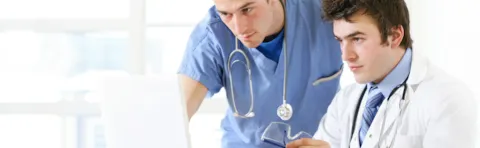 medical professionals work at a computer