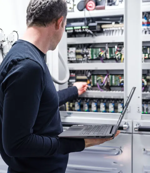 Electrician working on electronics cabinet