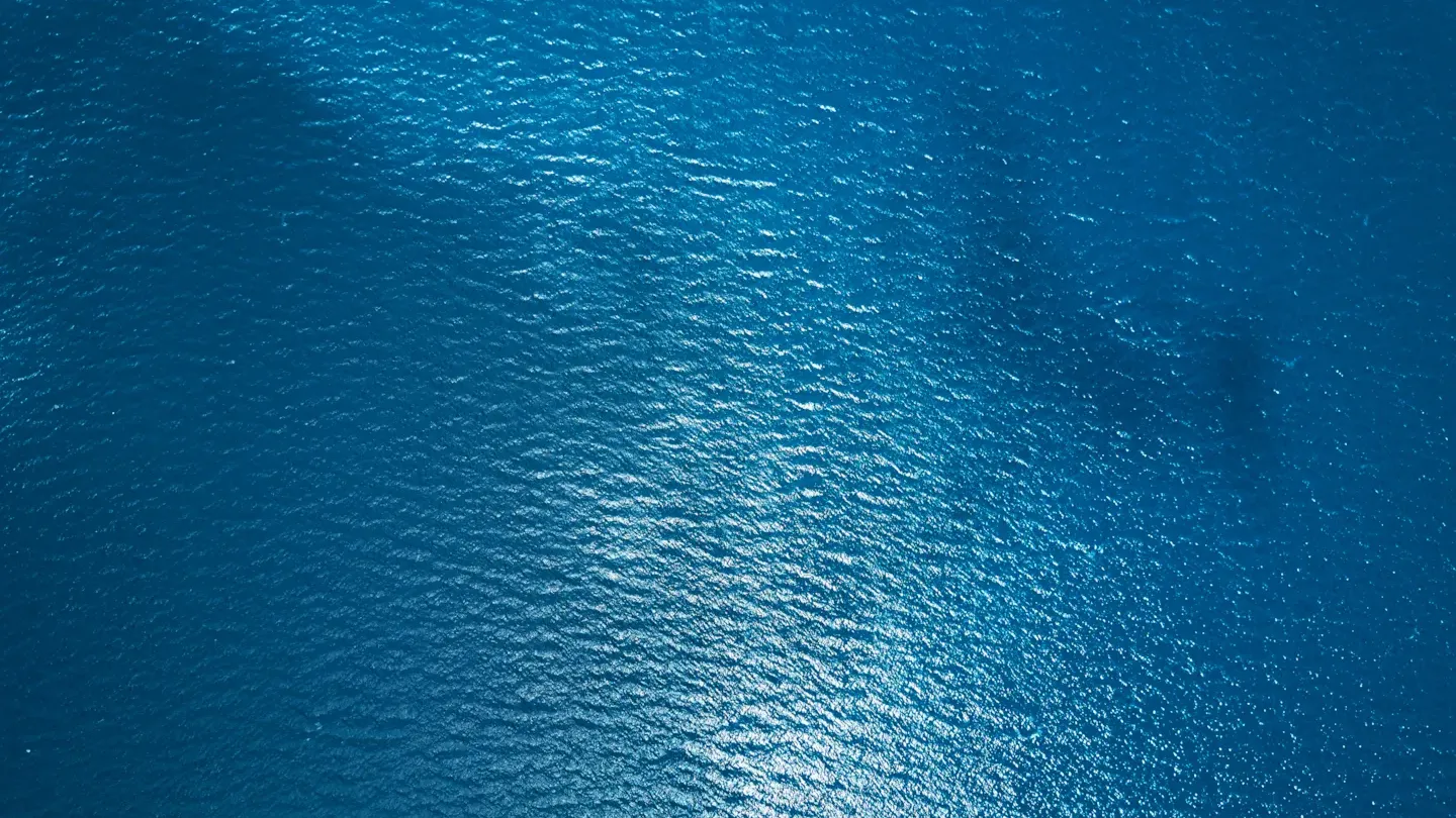 Close-up of calm blue ocean surface capturing environmental site conditions for aquaculture assessments.