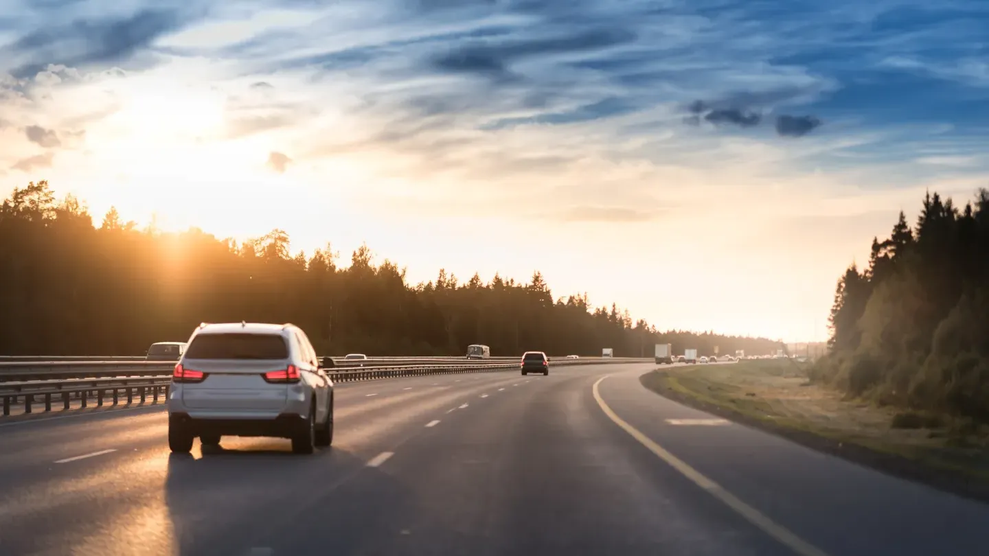 Car driving on an open road at sunrise, symbolizing ASPICE process maturity and improved automotive software performance