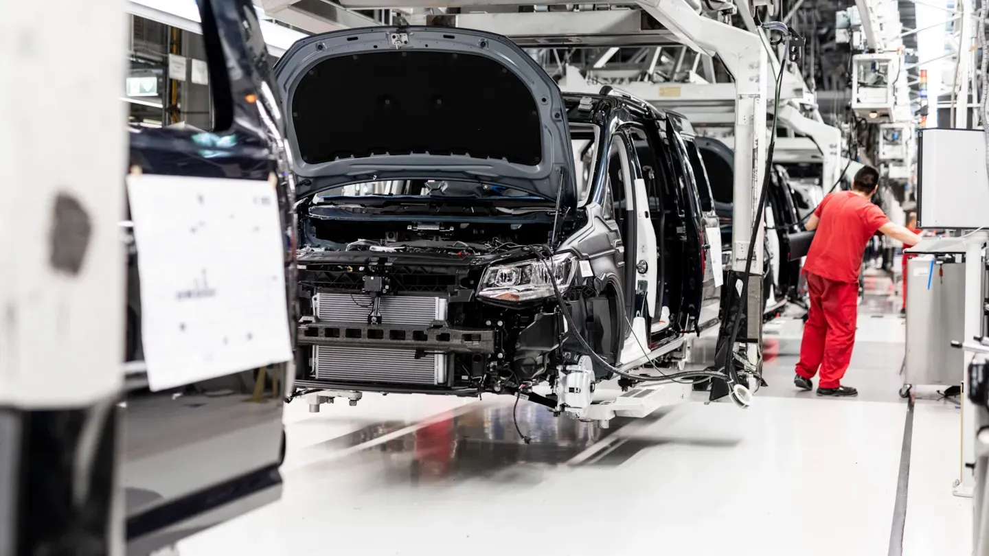 Technician working on a vehicle on the assembly line, representing early-stage safety concept development and technical review