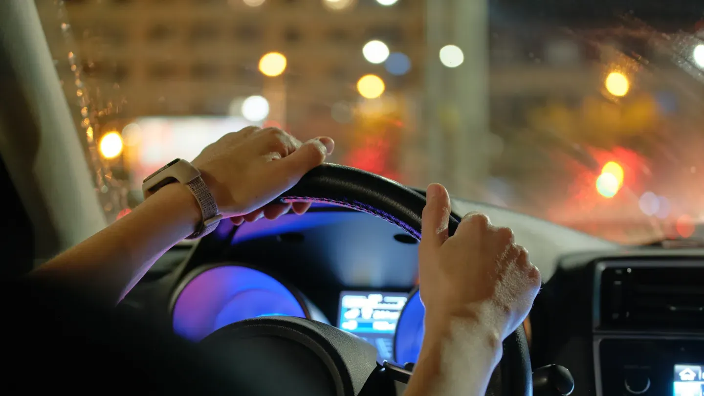 Driver interacting with an in-vehicle digital dashboard displaying cybersecurity alerts and system status during risk monitoring
