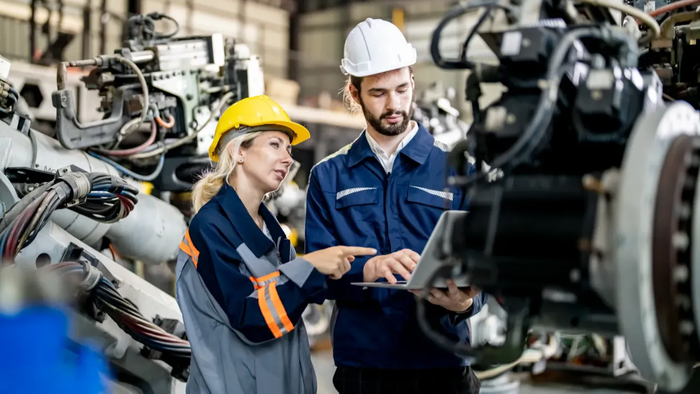 Engineers inspecting a vehicle engine in a manufacturing environment, representing verification and validation activities across the ISO 26262 lifecycle
