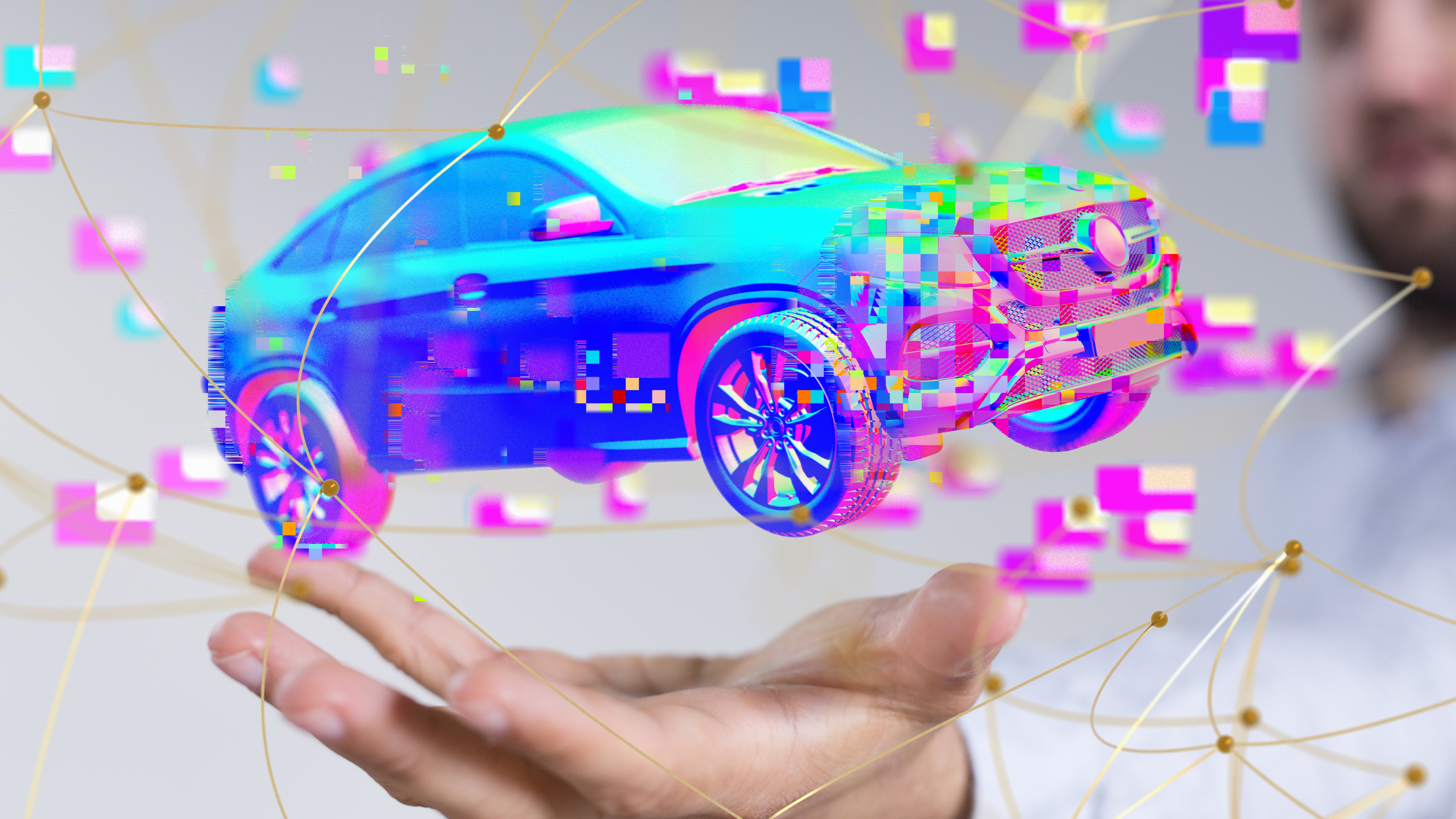 Digital hologram of a connected car hovering above a person’s hand, symbolising cybersecurity protection for automotive systems