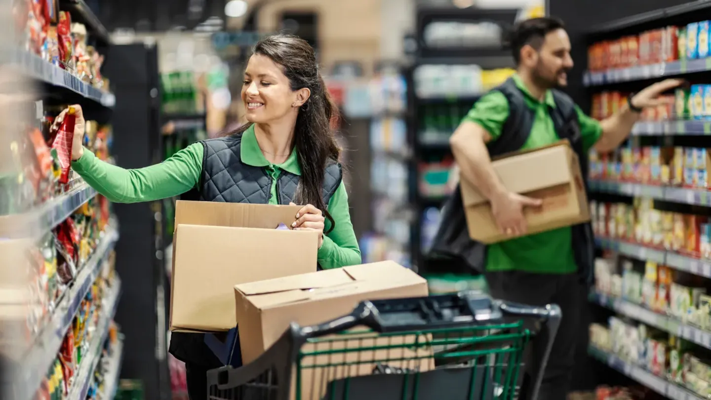 Shoppers pushing grocery carts through a supermarket aisle, representing retail operations and in-store audit environments