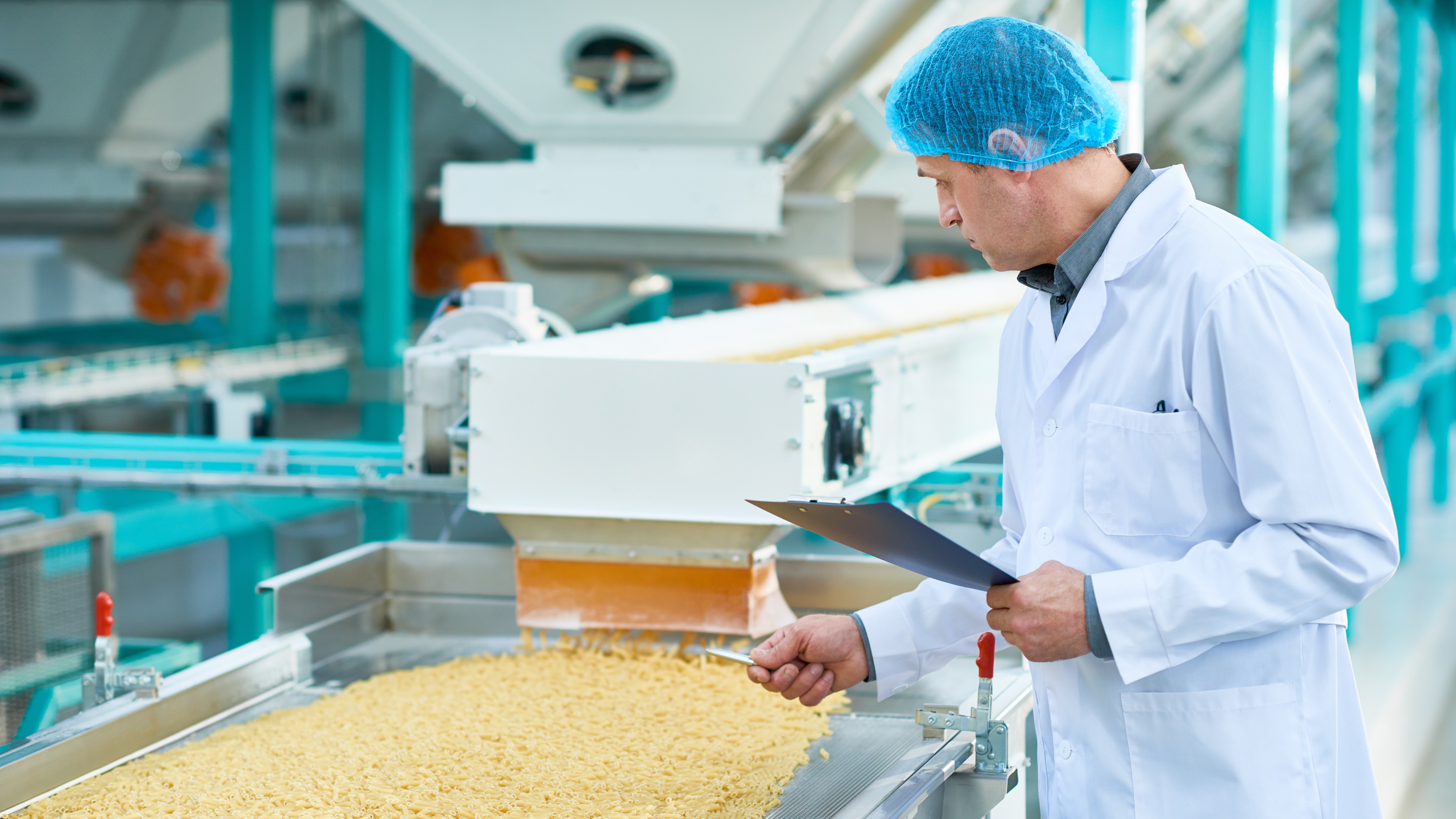 Food production line with quality inspection representing QHSE audits and assessments in manufacturing