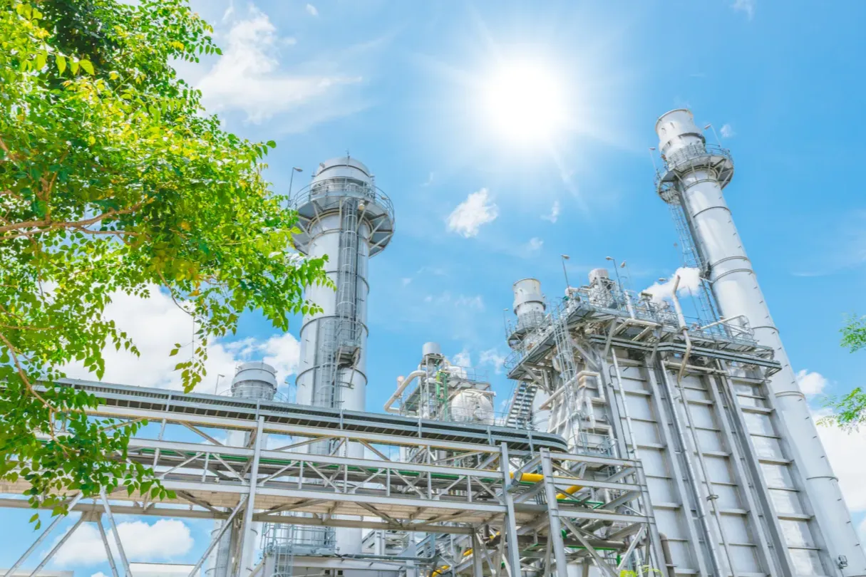 Industrial facility surrounded by greenery representing sustainability performance, emissions management, and lifecycle impact reduction