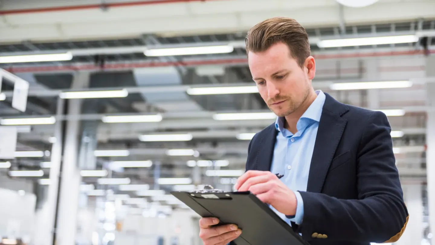 Professional conducting CBAM compliance review with digital tools in a manufacturing facility