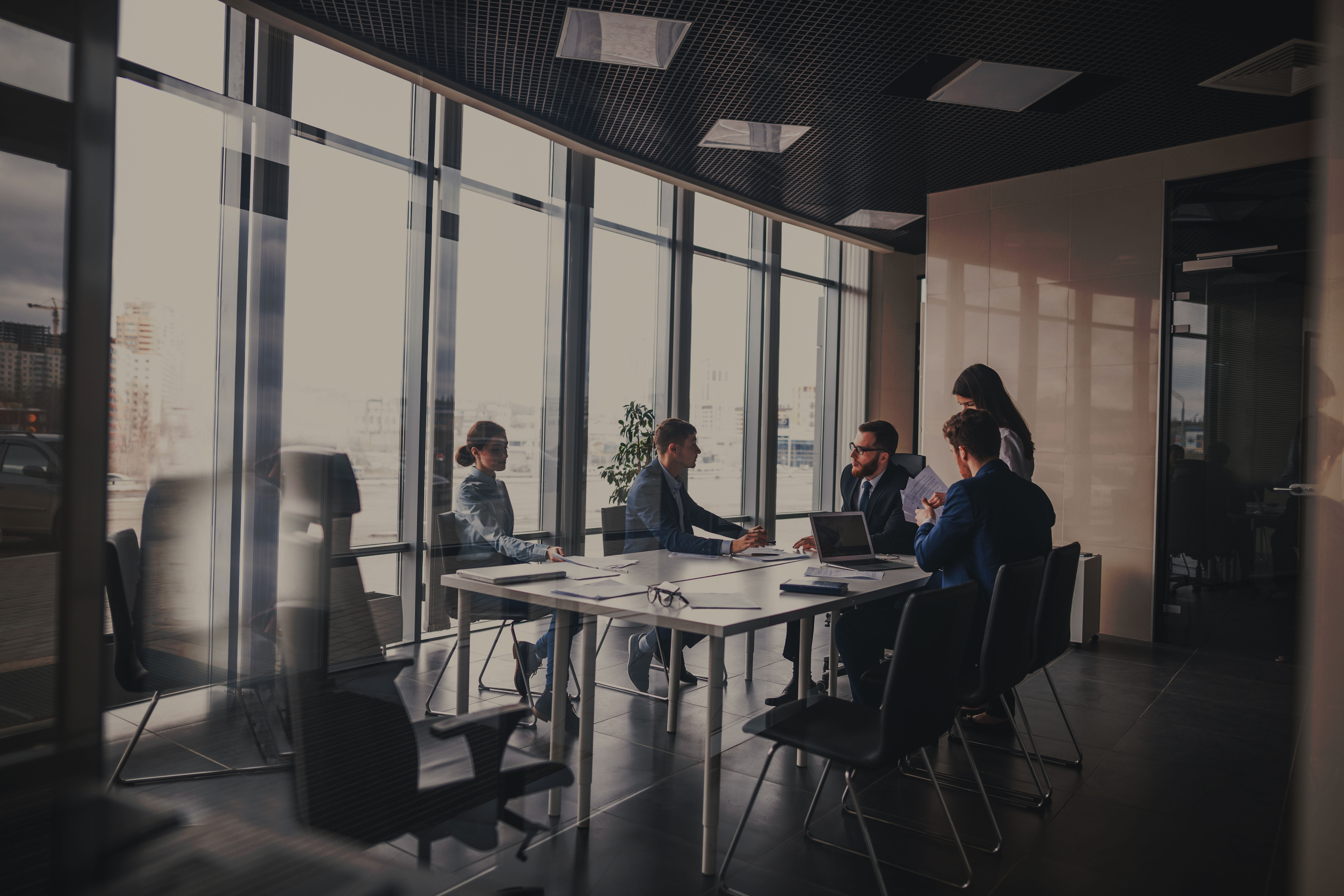 A business team discussing sustainability and risk strategies in a modern office meeting room, representing corporate strategy and decarbonization planning for hard-to-abate sectors.
