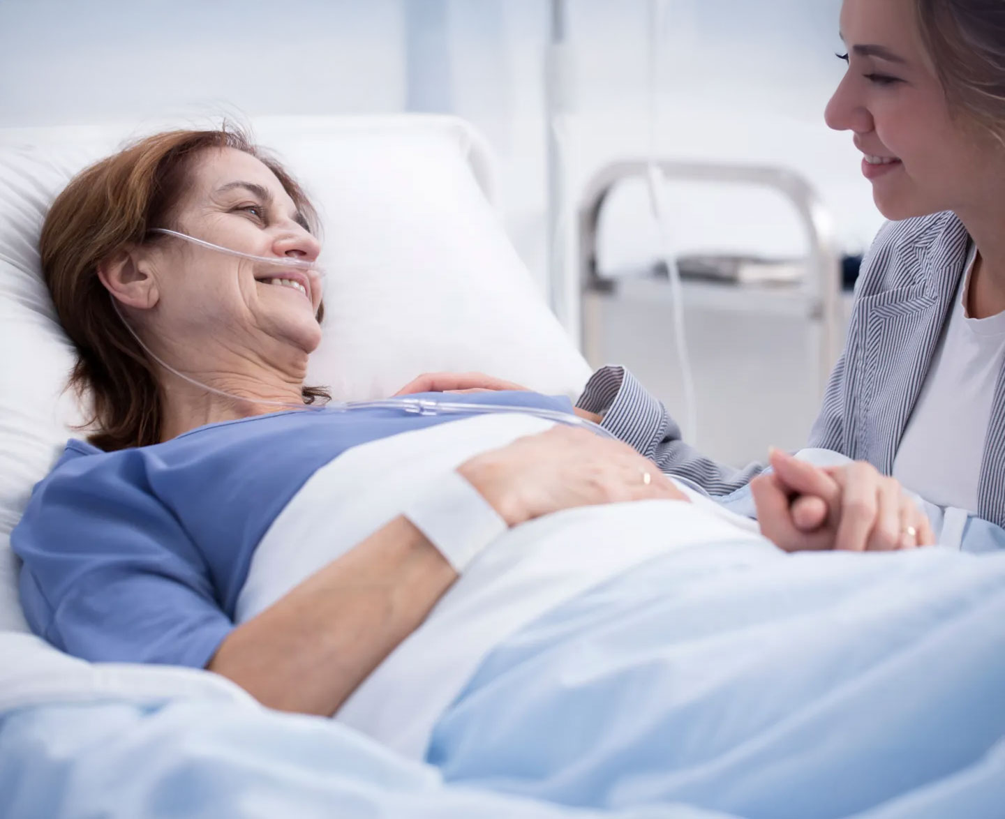 Nurse supporting a patient in a hospital bed, illustrating compassionate, high-quality palliative care aligned with DNV Advanced Palliative Care Certification