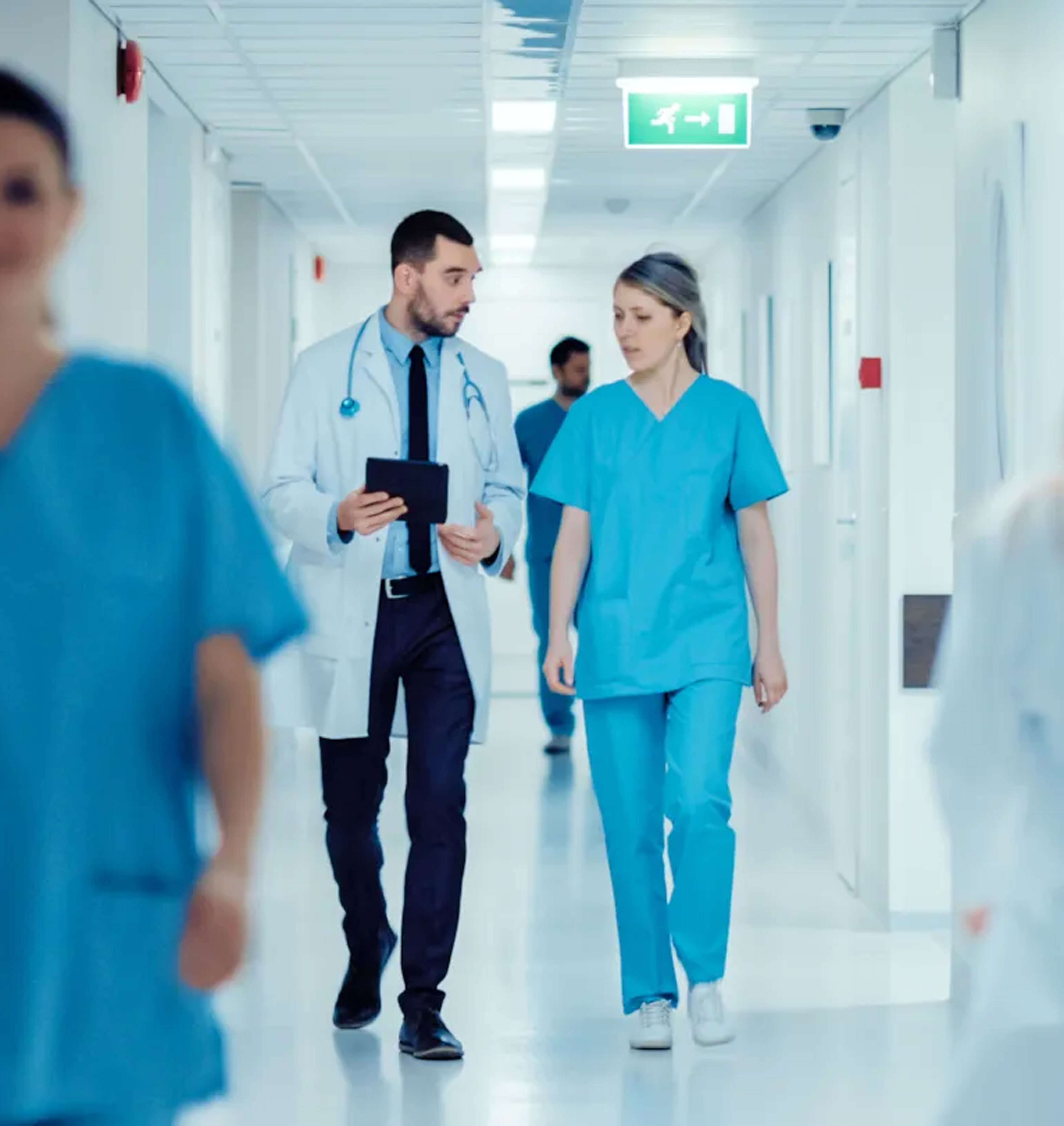 Healthcare professionals walking through a hospital corridor, representing coordinated, system-wide infection prevention supported by DNV’s CIP framework